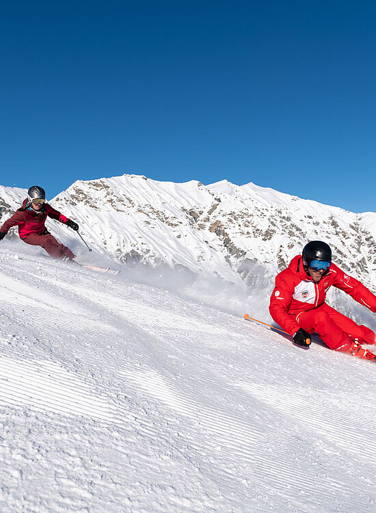 <p>Zwei Skifahrer mit Skilehrer auf Skipiste</p>