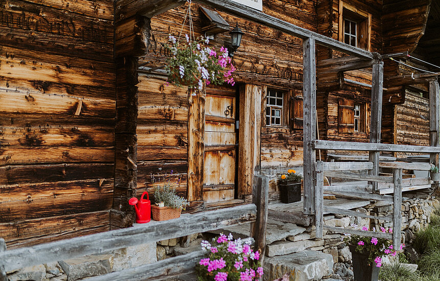 <p>Alphütte mit diversen Blumen vor der Hütte</p>